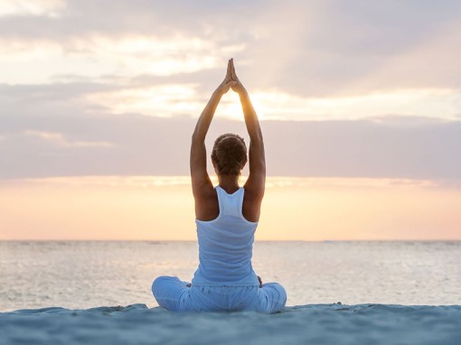 Caucasian woman practicing yoga at seashore